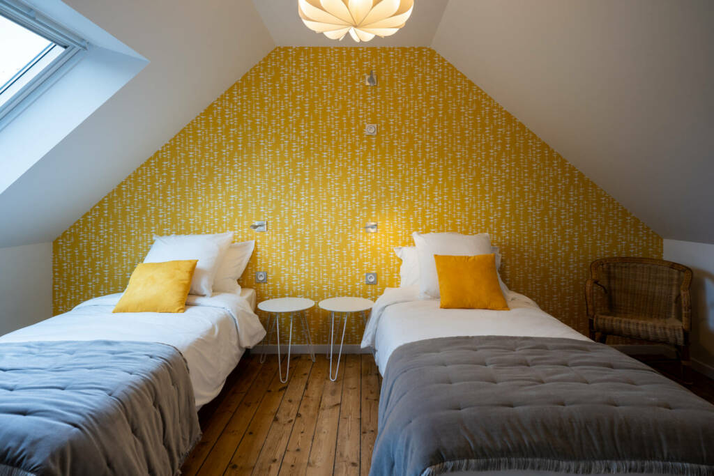 Une chambre double sous les rampants avec un papier peint jaune Missprint, par l'Agence Bérénice Alandi, Architecte d'intérieur en Finistère Sud 29