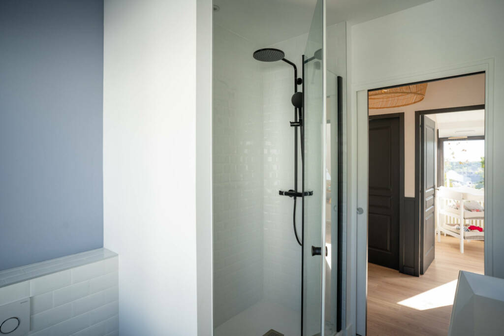 Détails sur la carrelage métro et la robinetterie noir mat de cette salle de bain, par l'Agence Bérénice Alandi, Architecte d'intérieur en Finistère Sud 29